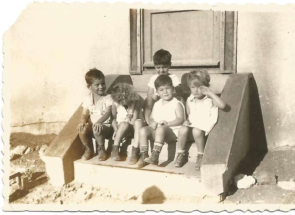 תמונה של ילדים יושבים על מדרגות בית א
